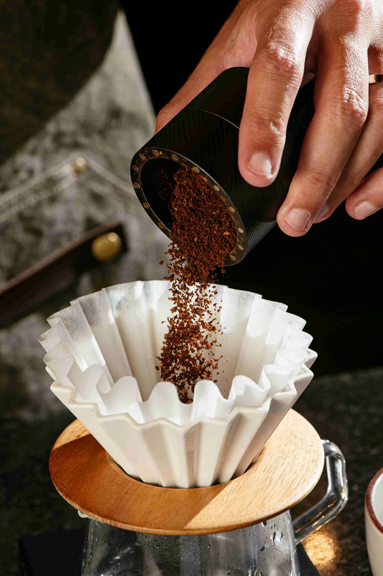 Café moído na hora sendo despejado em filtro de papel para preparo de café coado